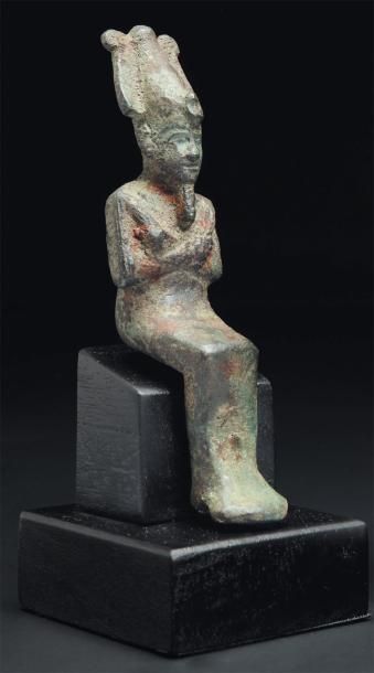 ÉGYPTE Statuette votive représentant le dieu Osiris. Il est assis, les mains émergeant...