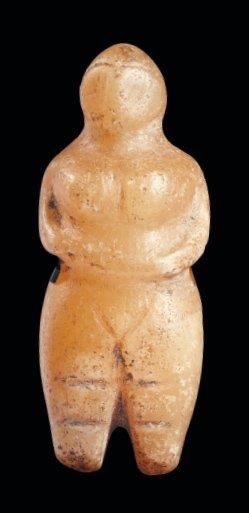 ORIENT Idole féminine. Rare statuette représentant une femme nue, stylisée, debout,...