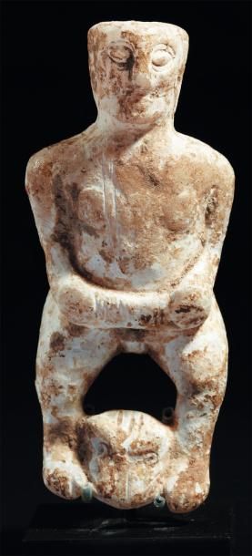 ORIENT Statuette représentant une femme nue stéatopyge, debout au-dessus d'une tête...