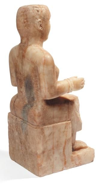 ORIENT Exceptionnelle statue féminine. Elle est assise sur un siège cubique à piédestal,...