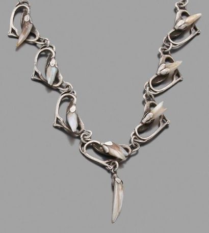 null Collier en argent orné de sept fleurs stylisées agrémentées chacune d'une nacre.
Travail...