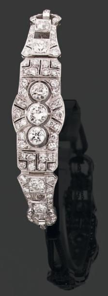 BRACELET articulé composé d'un long motif lanière, terminé par deux anneaux, à décor...