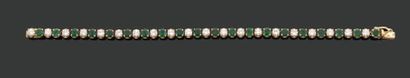  BRACELET ligne composé de vingt diamants brillantés séparés par des émeraudes rondes....