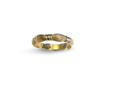 null Bracelet ouvrant en or jaune 18K (750) formé de motifs godronnés cintrés par...