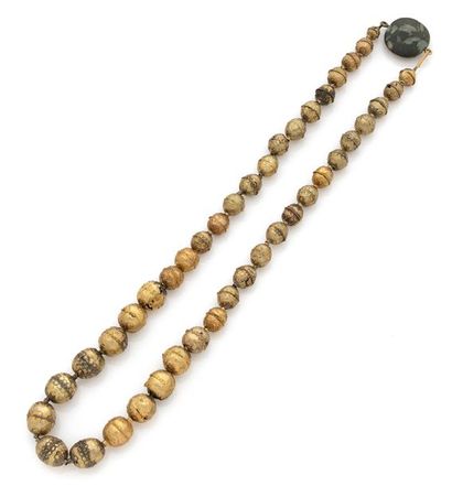 DANS LE GOÛT ROMAIN. 
Deux colliers formes de perles en metal dore et racine de rubis.
L:...