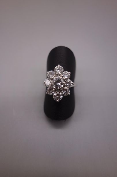 null Bague en or gris 18K (750/oo) figurant une fleur centrée d'un diamant taille...