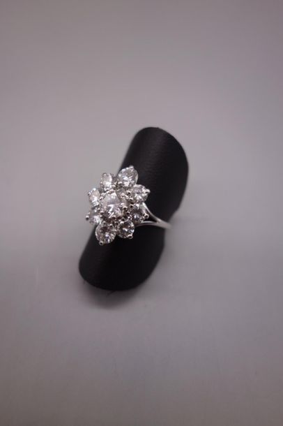 null Bague en or gris 18K (750/oo) figurant une fleur centrée d'un diamant taille...
