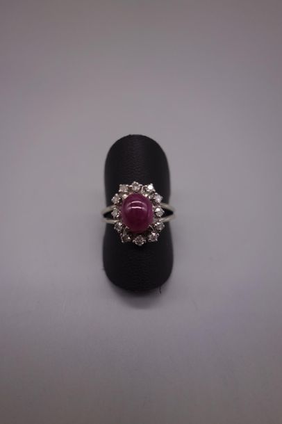 null Bague en or gris 18K (750/oo) sertie d'un cabochon de rubis dans un entourage...