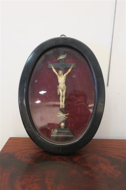 null Un crucifix en ivoire (?) dans un encadrement ovale sous verre. 