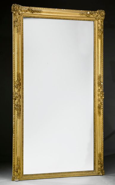 null Grand miroir en bois et stuc doré, encadrement en doucine gravée, ornée d'écoinçons...