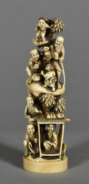 Chine, sculpture en ivoire, arbre garni de sept personnages rieurs et singe devant...