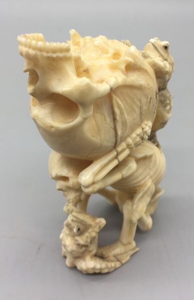 null Okimono en ivoire marin représentant un squelette assis portant sur son dos...