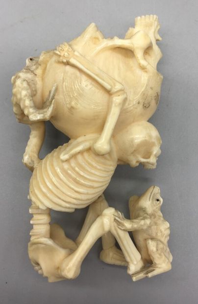 null Okimono en ivoire marin représentant un squelette assis portant sur son dos...