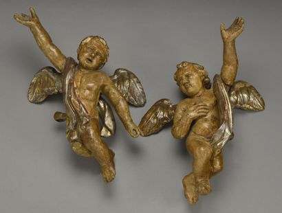 null Paire d'angelots drapés en bois sculpté, polychromé et argenté.

XVIIIème siècle.

H....