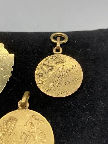 null Lot en or jaune 18K (750/oo) comprenant trois médailles religieuses, une Eucharistie,...