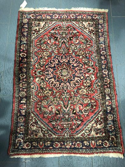 null Woolen carpet with knotted points with central decoration of a rose highlighted...