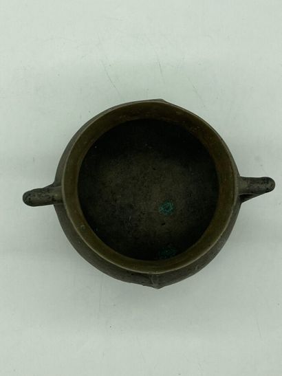 null Tripod pot in patinated bronze with a spherical body decorated with two handles....