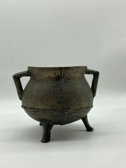 null Tripod pot in patinated bronze with a spherical body decorated with two handles....