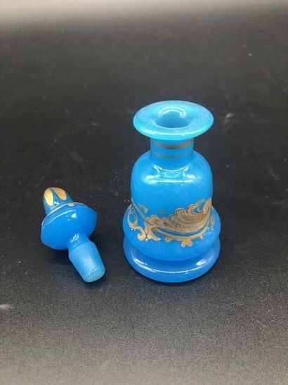 null Petit flacon en opaline bleue à décor or. 

XIXème siècle. 

H. 10,5 cm.
