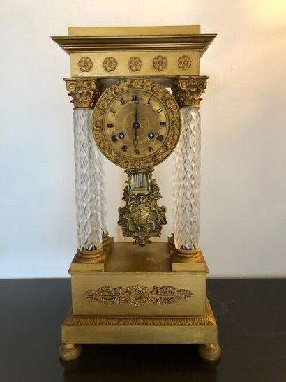 null A gilt bronze portico clock in the Empire style with a moulded and cut crystal...