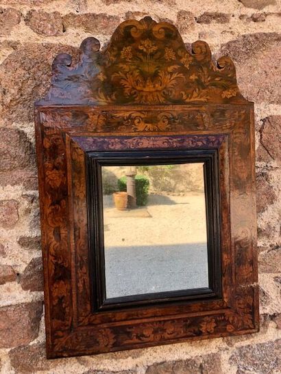 null An inverted profile mirror topped by a pediment decorated with a Dutch marquetry...