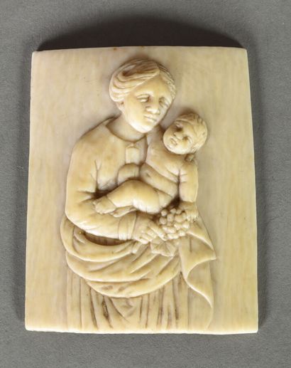 null Petite plaque en ivoire légèrement cintrée figurant la Vierge et l'Enfant aux...