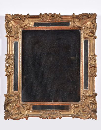  * Miroir à parcloses en bois sculpté redoré orné de coquilles et feuillages. 
XVIIIème...