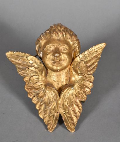  * Petite tête d'ange ailée sculptée en bois doré. 
XIXème siècle. 
H. 27 cm 
Accidents,...