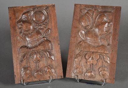 null Two hanging panels in carved oak showing profiles of characters on leafy branches....