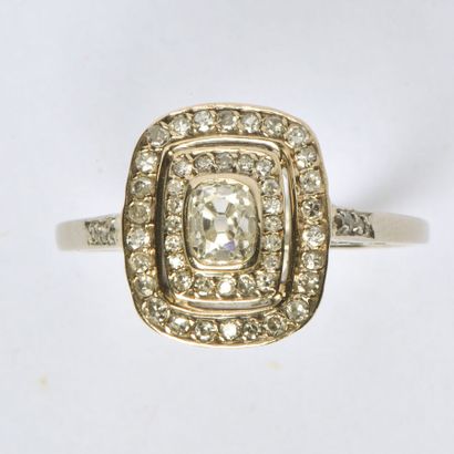  Platinum ring (850/oo), the rectangular cushion-shaped plate centered with a diamond...