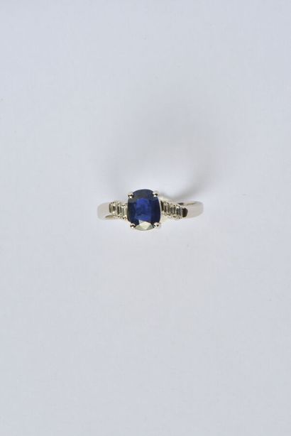 null 18K (750/oo) white gold cross ring centered with an oval sapphire weighing approximately...