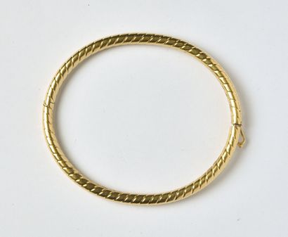 null Bracelet jonc rigide ouvrant en or jaune 18K (750/oo) lisse à décor strié. Jeu...