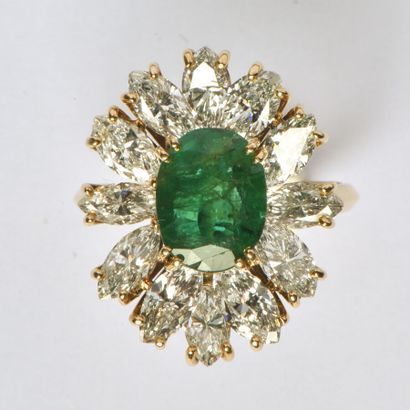 null 18K (750/oo) yellow gold "Flower" ring centered on an oval emerald weighing...