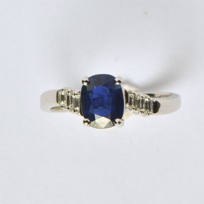 null 18K (750/oo) white gold cross ring centered with an oval sapphire weighing approximately...