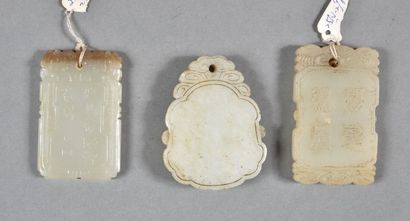 null Trois pendentifs en jade céladon, deux rectangulaires ornés en léger relief,...