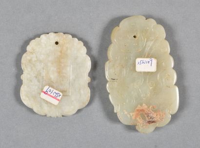 null Two celadon jade pendants, one carved on both sides with a phoenix in slight...