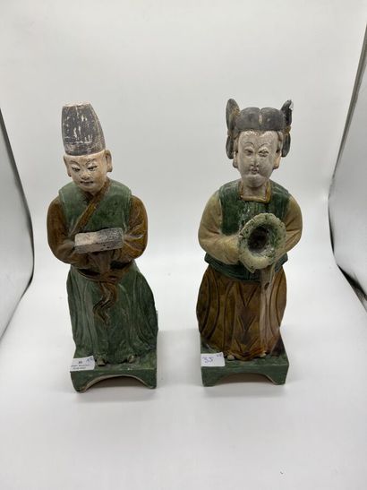 null Two green and ochre glazed ceramic subjects representing a couple of offering...