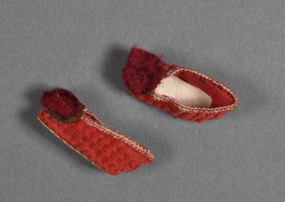 Pair of red ribbed slippers bordered by braid,...