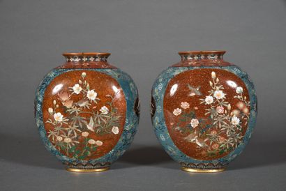 null A pair of enamelled copper shippo vases, the rounded and flattened body decorated...