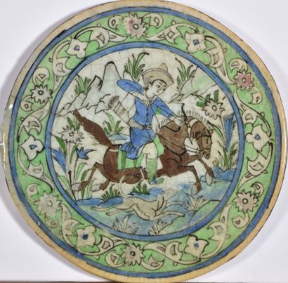 null IRAN Kadjar around 1920.

Circular ceramic tile decorated with a horseman shooting...