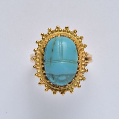 null Bague en or jaune 18K (750/oo) centrée d'une turquoise sculptée figurant un...