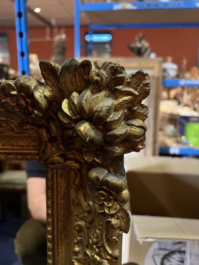 null * Miroir formé d'un cadre en bois et stuc doré à décor de rinceaux et fleurs.

XXème...