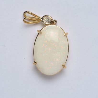 null 18K (750/oo) yellow gold pendant set with an oval opal cabochon topped by an...