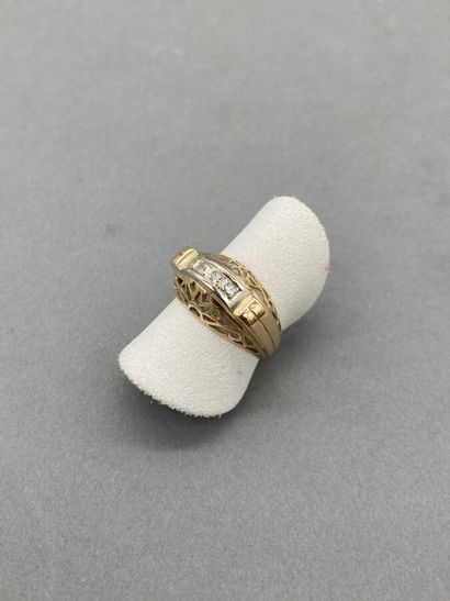 null An 18K (750/oo) two-tone gold ring with an openwork design centered on a line...