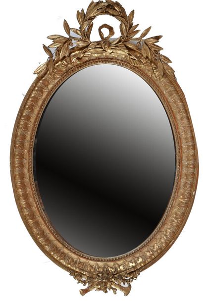 null Oval view mirror in wood and gilded stucco, decorated with foliage, laurel wreath...