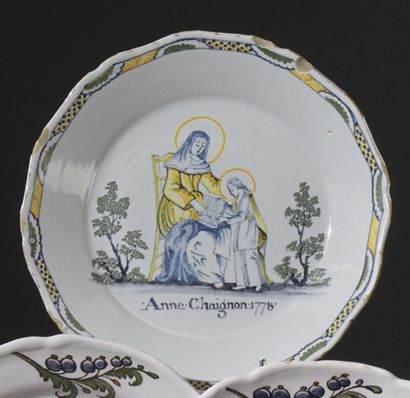 null Nevers. 
Assiette en faïence au bord contourné, décor polychrome patronymique...