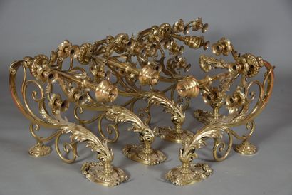 Five brass and bronze sconces, arms in leafy...