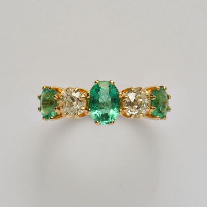 null 18K (750/oo) yellow gold garter ring set with a line of oval emeralds alternating...