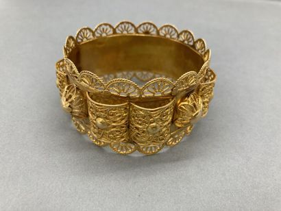 null Un bracelet rigide or à motifs filigranés et appliqués, bossué, 59,9 g.