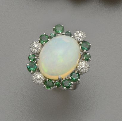 null An 18K (750/oo) white gold ring centered on a cabochon of oval opal weighing...